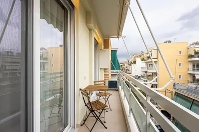 a balcony with chairs and a table on a building at Stylish Central Athens Apartment in Athens