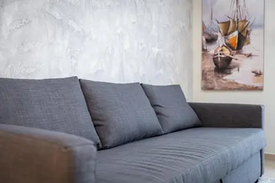 a gray couch in a living room with a painting at Stylish Central Athens Apartment in Athens