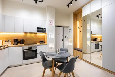 a kitchen with white cabinets and a table and chairs at Stylish Central Athens Apartment in Athens
