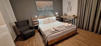 a small bedroom with a bed and a chair at Homy in Athens