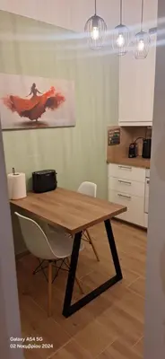 a kitchen with a wooden table with a chair at Homy in Athens