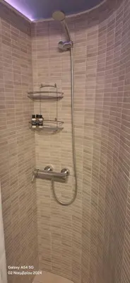 a shower in a bathroom with a hose on the wall at Homy in Athens