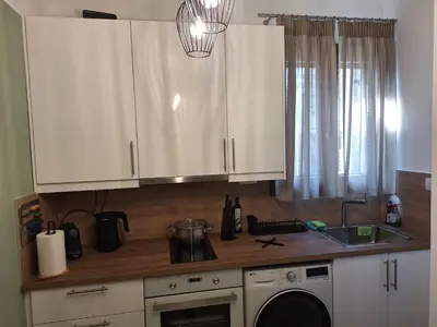 a kitchen with white cabinets and a sink at Homy in Athens
