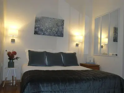 a bedroom with a bed with two lamps and a painting at Lux Studio Apartment at Kolonaki in Athens