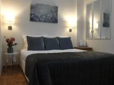 a bedroom with a large bed in a room with two lamps at Lux Studio Apartment at Kolonaki in Athens