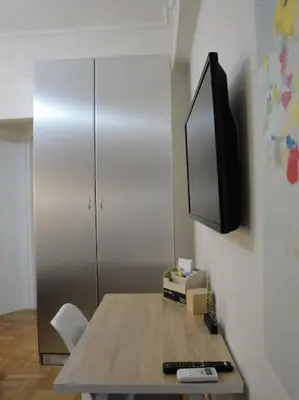 a room with a table with a tv on a wall at Lux Studio Apartment at Kolonaki in Athens