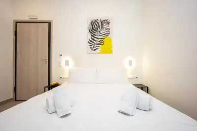 a white bedroom with a white bed and a zebra painting at DownTown Vibes 2 in Athens