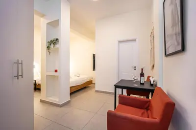 a room with a red chair and a table and a bed at DownTown Vibes 2 in Athens