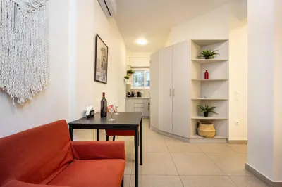 a living room with a table and a red chair at DownTown Vibes 2 in Athens