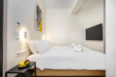a bedroom with a white bed and a table with fruit on it at DownTown Vibes 2 in Athens