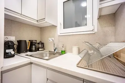 a kitchen with white cabinets and a sink at DownTown vibes #1 in Athens