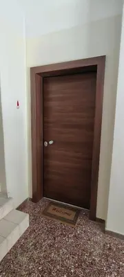 a wooden door in a room with a mat in front of it at VK apartment in Athens