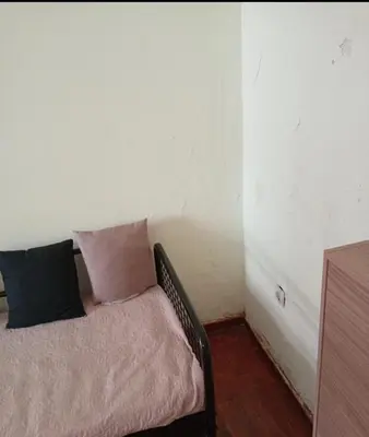 a corner of a room with a couch with pillows at Simple apartment in Athens