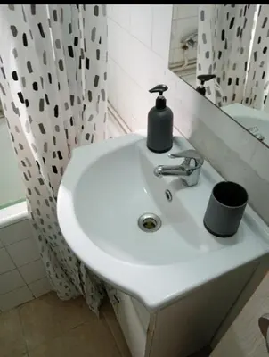 a white sink in a bathroom with a shower at Simple apartment in Athens