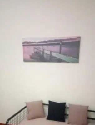 a painting hanging on a wall above a couch at Simple apartment in Athens