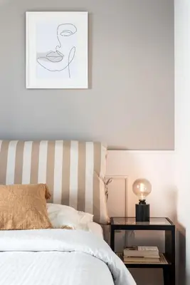 a bedroom with a bed and a table with a picture at Elegant & Roomy 3-Bedroom Apartment in the Heart of Glyfada in Athens