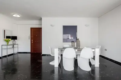 a dining room with a table and white chairs at Elegant & Roomy 3-Bedroom Apartment in the Heart of Glyfada in Athens