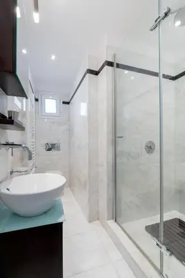 a bathroom with a sink and a glass shower at Elegant & Roomy 3-Bedroom Apartment in the Heart of Glyfada in Athens