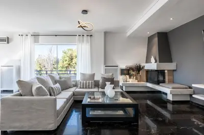 a living room with a couch and a fireplace at Elegant & Roomy 3-Bedroom Apartment in the Heart of Glyfada in Athens