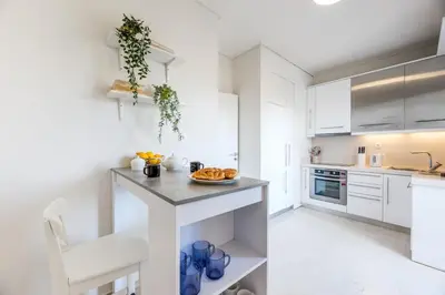 a white kitchen with a counter with a plate of food on it at Elegant & Roomy 3-Bedroom Apartment in the Heart of Glyfada in Athens