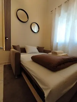 two beds in a room with a mirror on the wall at Cozy Attiki apartment by MPS in Athens