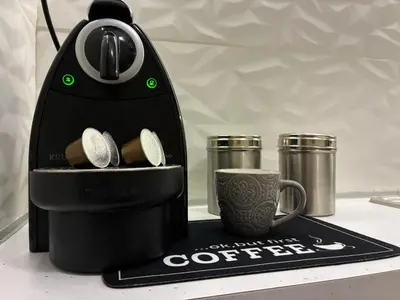 a black coffee maker and a cup on a counter at Cozy Attiki apartment by MPS in Athens