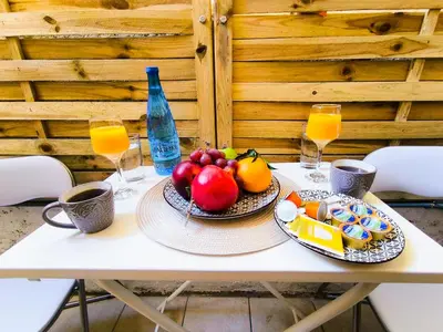 a table with a plate of fruit and orange juice at Cozy Attiki apartment by MPS in Athens