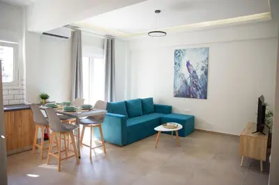 a living room with a blue couch and a table at The Athens Getaway Apartment in Athens