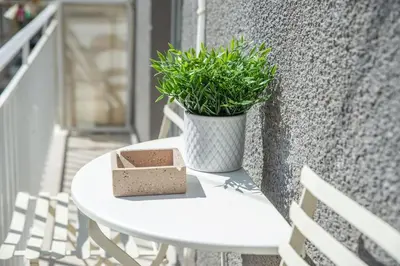 a white table with a plant on a balcony at The Athens Getaway Apartment in Athens