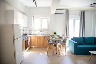 a kitchen with a blue couch and a table with chairs at The Athens Getaway Apartment in Athens
