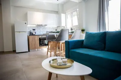 a living room with a blue couch and a table at The Athens Getaway Apartment in Athens