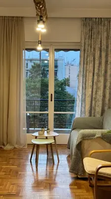 a living room with a table in front of a window at Olēa House at Monastiraki in Athens