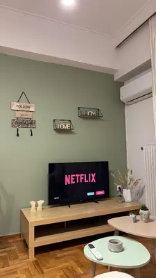 a living room with a flat screen tv on a wall at Olēa House at Monastiraki in Athens