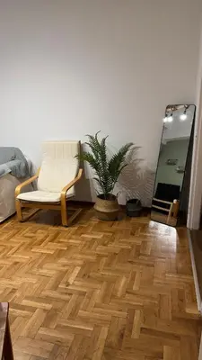 a living room with a chair and a wooden floor at Olēa House at Monastiraki in Athens