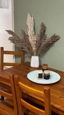 a wooden table with a plate and a vase on it at Olēa House at Monastiraki in Athens