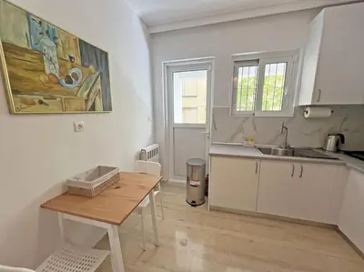 a kitchen with a wooden table and a sink at Apartment near megaro mousikis metro station in Athens