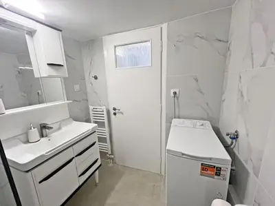 a white bathroom with a sink and a mirror at Apartment near megaro mousikis metro station in Athens