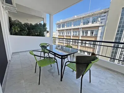 a balcony with a table and chairs on a balcony at Apartment near megaro mousikis metro station in Athens
