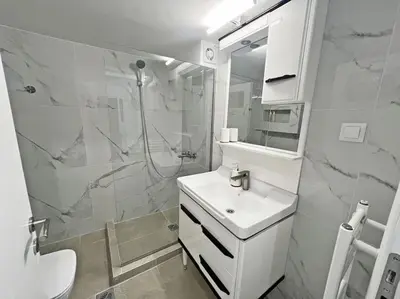 a white bathroom with a sink and a shower at Apartment near megaro mousikis metro station in Athens