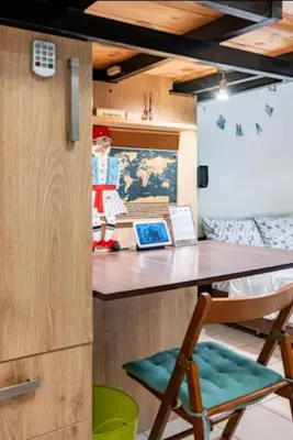 a kitchen with a counter with a table and a stool at Έξυπνο στουντιο ημιυπόγειο στην Αθήνα με αυλή in Athens