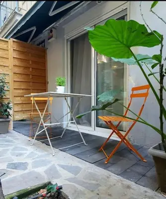 a patio with a table and two chairs and a plant at Έξυπνο στουντιο ημιυπόγειο στην Αθήνα με αυλή in Athens