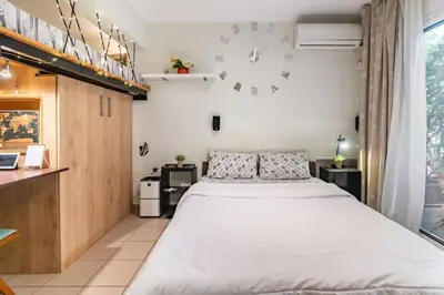 a bedroom with a bed and a clock on the wall at Έξυπνο στουντιο ημιυπόγειο στην Αθήνα με αυλή in Athens
