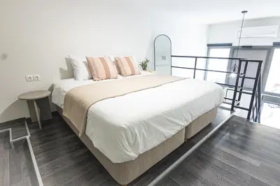 a bedroom with a large bed and a table at Loft15Athens in Athens