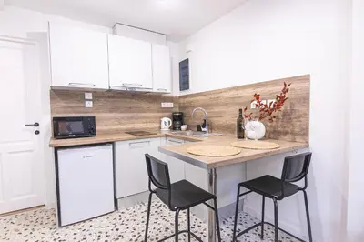 a kitchen with white cabinets and black stools at Loft15Athens in Athens