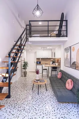 a living room with a couch and a staircase at Loft15Athens in Athens