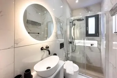 a bathroom with a sink and a toilet and a mirror at Villa Redi Relaxing Spa in Piraeus