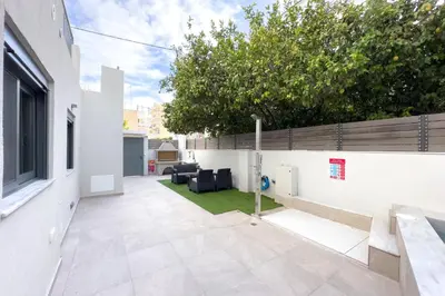 a courtyard in a house with a white wall at Villa Redi Relaxing Spa in Piraeus