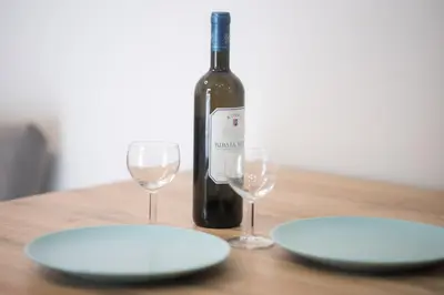 a bottle of wine and two glasses on a table at Villa Redi Relaxing Spa in Piraeus