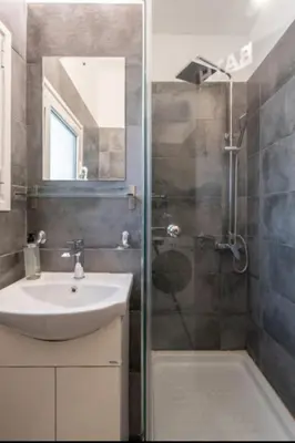 a bathroom with a sink and a shower with a sink at Koukaki Hideaway Suite in Athens