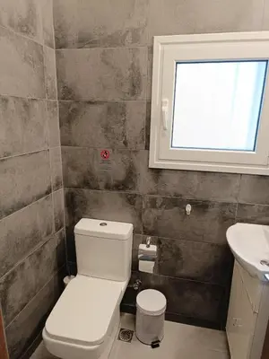 a bathroom with a toilet and a sink and a window at Koukaki Hideaway Suite in Athens
